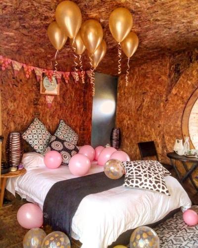 a bedroom with a bed with pink balloons on it at Glampings Magic Bungalow in Villa de Leyva