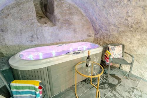 a bath tub sitting next to a chair in a room at 2 Bed in Tenby oc-b41402 in Tenby