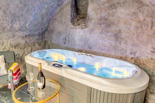 a bathroom with a tub with a table and a bottle of wine at 2 Bed in Tenby oc-b41400 in Tenby
