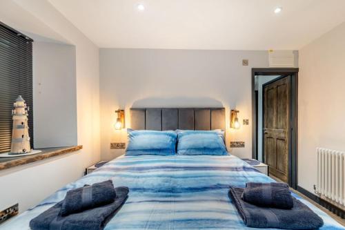 a bedroom with a large bed with blue pillows at 2 Bed in Tenby oc-b41399 in Tenby