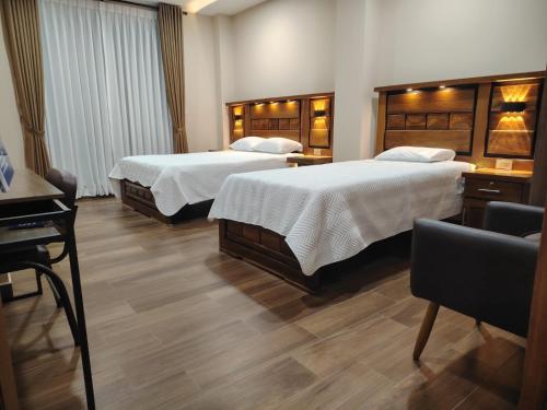 a hotel room with two beds and a piano at Hotel Central in Cochabamba