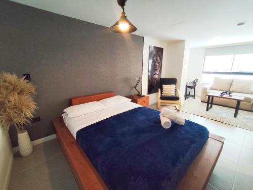 a bedroom with a large bed with a blue blanket at GURUS FR | Cómodo Elegante cerca Termales in Santa Rosa de Cabal