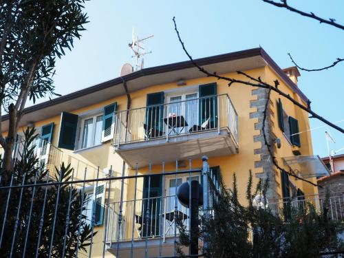 a yellow building with a balcony with chairs on it at Pietra Di Mare in Biassa