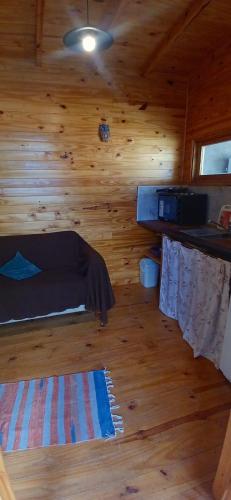 a room with a bed in a wooden cabin at Refugio La Lechuza in San Rafael