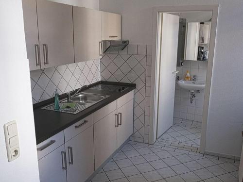 a small kitchen with a sink and a bathroom at Courtyard Idyll Apartment in Rostock