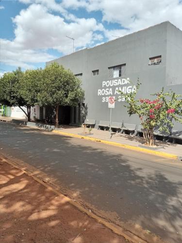 a building with a sign on the side of a street at ''Pousada Rosa Amiga'' in Barretos