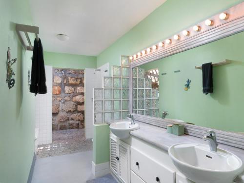 a bathroom with two sinks and a large mirror at Stunning Views Oceanfront Oasis with Private Pool - Inch by Inch in Christ Church