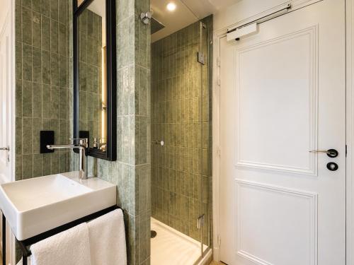 a bathroom with a sink and a shower at Hotel Maison Lenoir in Paris