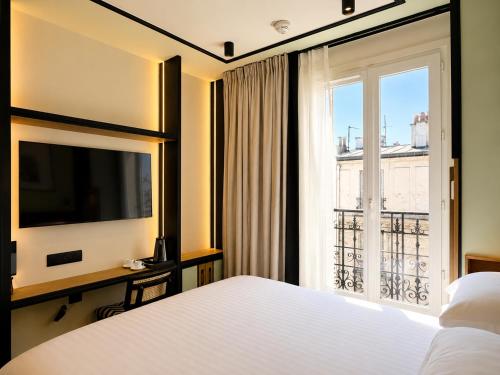 a bedroom with a bed and a large window at Hotel Maison Lenoir in Paris