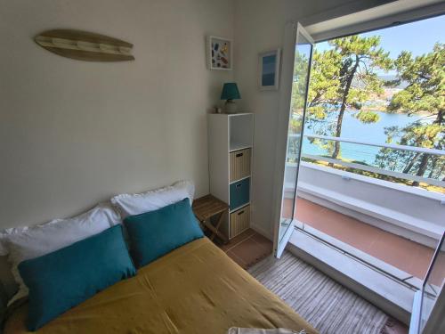 ein Schlafzimmer mit einem Bett und Blick auf einen Balkon in der Unterkunft Cabedelo River Flat in Darque