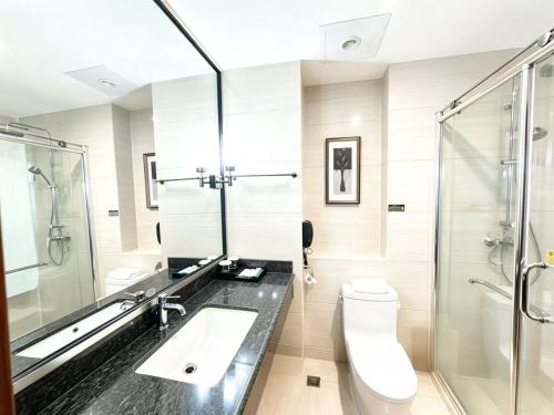 a bathroom with a toilet and a sink and a shower at Dayi Yihao hotel in Xiamen