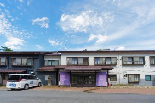 a white van parked in front of a building at Kusatsu Onsen Eidaya in Kusatsu