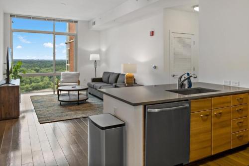 a kitchen with a sink and a living room at Hala Tysons in McLean