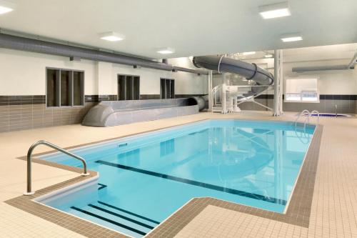 a large swimming pool in a hospital room with a slide at Days Inn & Suites by Wyndham Warman in Warman