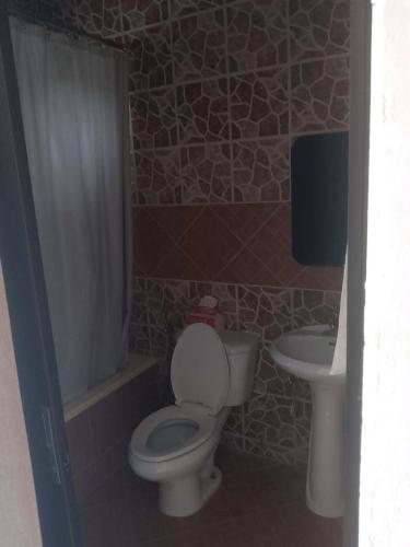 a bathroom with a toilet and a sink at Gemini Hotel & Restaurant in Libaong