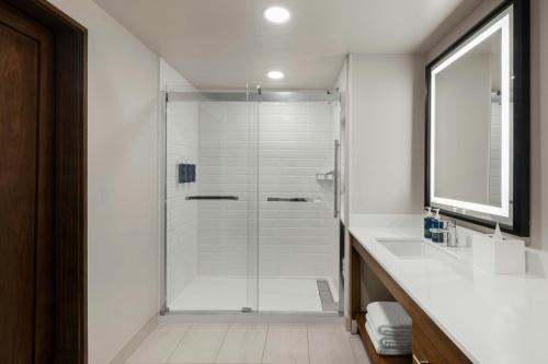 a bathroom with a shower with a sink and a mirror at Four Points by Sheraton Rock Springs in Rock Springs