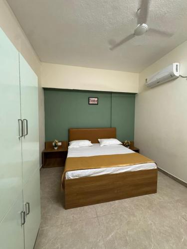 a bedroom with a bed and a green wall at Laya Crest in Chennai