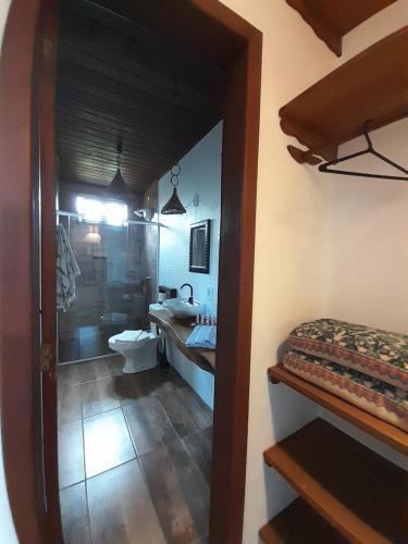 a bathroom with a sink and a toilet and a mirror at Santa Monica Hospedaria in Praia do Rosa
