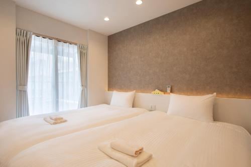 a bedroom with two beds and a window at New! 3A Home 難波&道頓堀直通 2LDK一棟貸切 最大4名 in Osaka