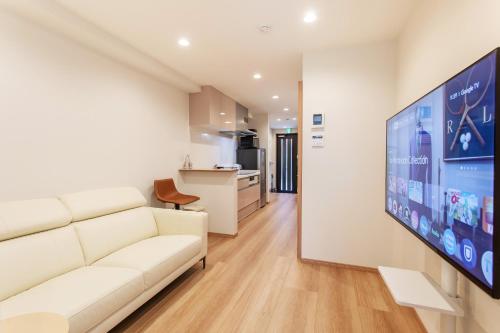 a living room with a white couch and a flat screen tv at New! 3A Home 難波&道頓堀直通 2LDK一棟貸切 最大4名 in Osaka
