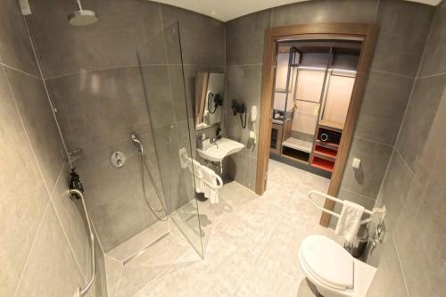 a bathroom with a shower and a toilet and a sink at Ramada Encore by Wyndham Konya Selcuklu in Konya