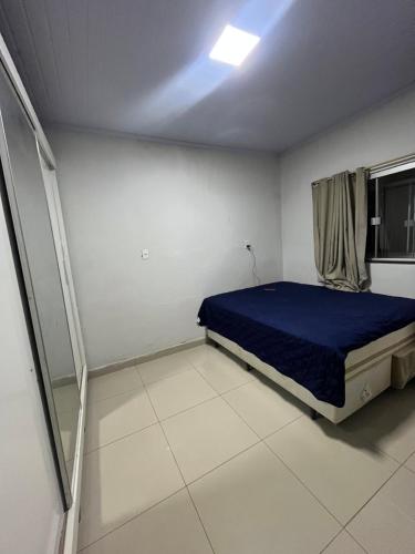 a bedroom with a blue bed and a window at Vieira House in Brasília