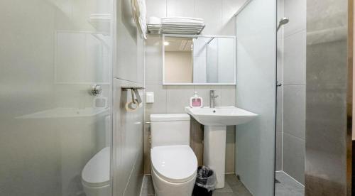 a white bathroom with a toilet and a sink at Jongno The Stay Korea in Seoul