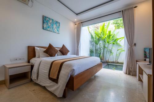 a bedroom with a bed and a large window at Bali Residence Villa in Uluwatu