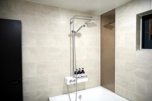 a shower stall in a bathroom with a sink at 진해프렌치코드호텔 in Chinhae