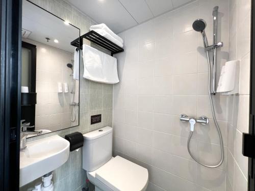 a bathroom with a shower and a toilet and a sink at Bridal Tea House Hotel - Yaumatei in Hong Kong