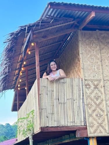 a woman standing on the balcony of a building at RM's Tourist Inn in Carmen