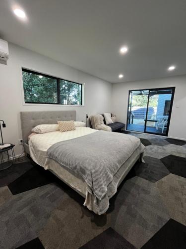 a bedroom with a large bed and two windows at 2 Bedroom Comfortable Guest Wing in Hamilton