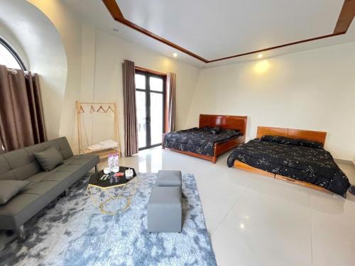 a living room with two beds and a couch at Home Me 2 in Dong Hoi
