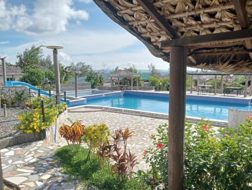 a large swimming pool in a resort with plants at Bregil Villas in Pagudpud