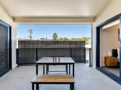 a patio with a table and benches on a balcony at 3BR Top Floor Apartment with Parking, EV friendly & Views Brisbane South in Brisbane
