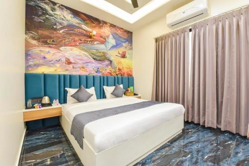 a bedroom with a large bed with a painting on the wall at Hotel Starlink By The Nine Hotel in Jaipur