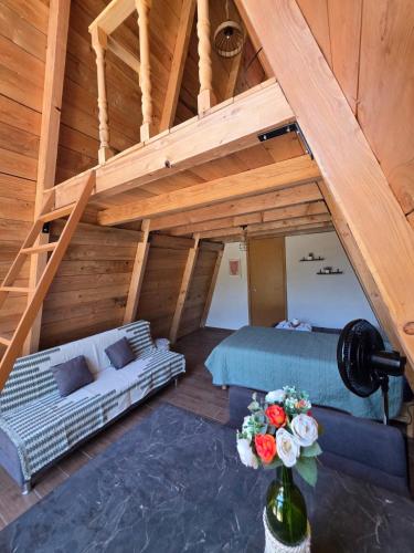 an attic room with a couch and a table with flowers at Chalet Niquel in Mineral del Chico