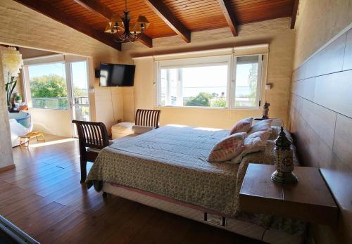 a bedroom with a bed in a room with windows at Retiro de Las Cañas in Fray Bentos