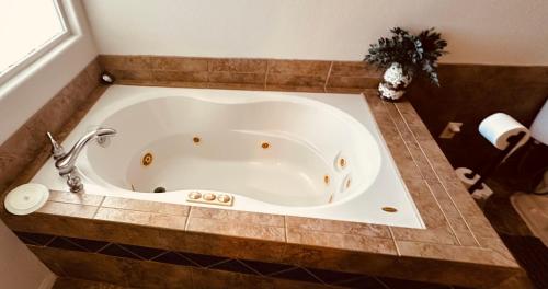 a bath tub in a bathroom with a tiled floor at Desert Vista View in Desert Hot Springs