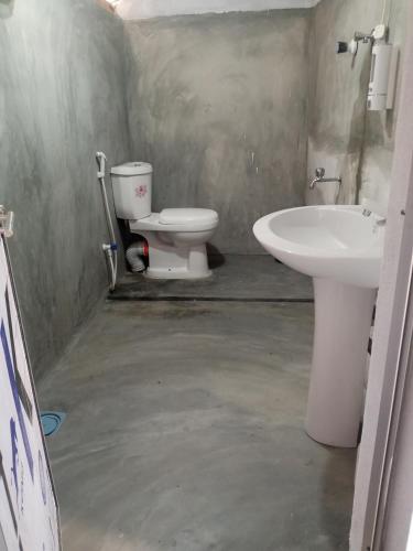 a bathroom with a toilet and a sink at HELLO MADHi VILLA in Arugam Bay