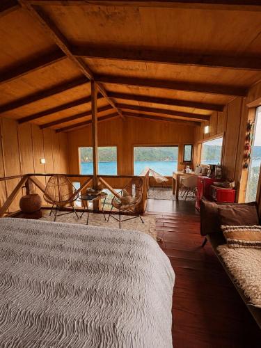 a bedroom with a bed in a room with windows at Pumillahue Lodge cabaña matrimonial in Ancud