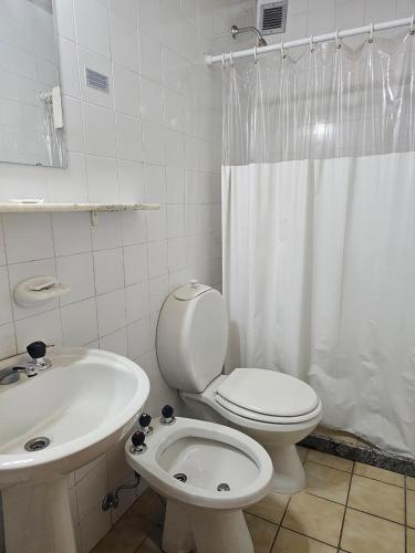 a white bathroom with a toilet and a sink at Depto 7 personas - Edificio Cirrus in Las Lenas
