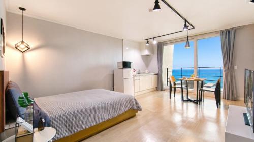 a bedroom with a bed and a table with chairs at Yeosu Harushimpyo Pension in Yeosu