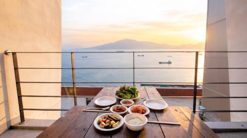 a table with plates of food on a balcony at Yeosu Harushimpyo Pension in Yeosu