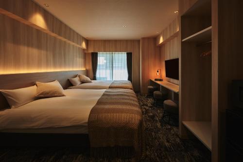 a hotel room with two beds and a window at Moat Inside Hakata in Fukuoka