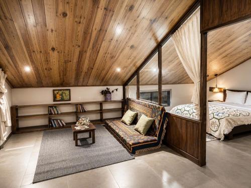 a bedroom with a bed and a couch in a room at An Valley Villa Đà Lạt in Da Lat