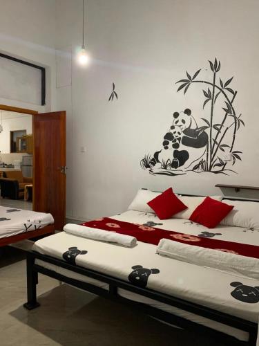 a bedroom with two beds and a panda picture on the wall at Gagana Vila 01 in Kandy