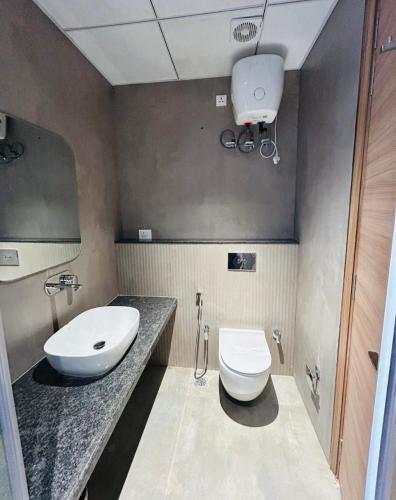 a bathroom with a white toilet and a sink at Hotel Layover Stay-3 Minutes From the Airport in Jaipur