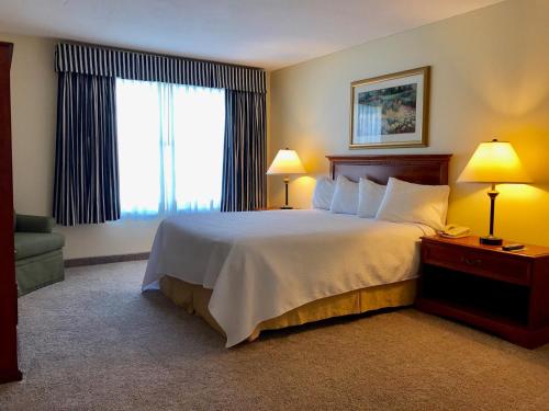 a hotel room with a large bed and a window at White River Inn & Suites in White River Junction