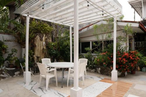 a white table and chairs under a white pergola at En Pensionne Comfort in Iloilo City